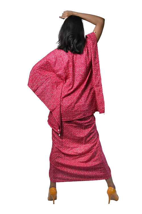 Back view of a woman in a vibrant pink Bandhani dhoti dress, showcasing intricate patterns and contemporary style.